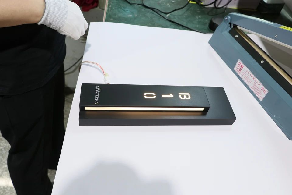 Illuminated electronic hotel door sign undergoing function testing